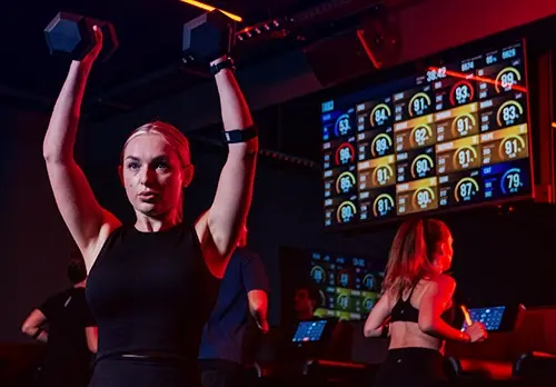 Woman lifting weights in a TRIB3 workout