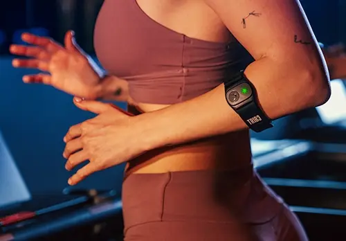 Woman on treadmill wearing the SWEAT Band